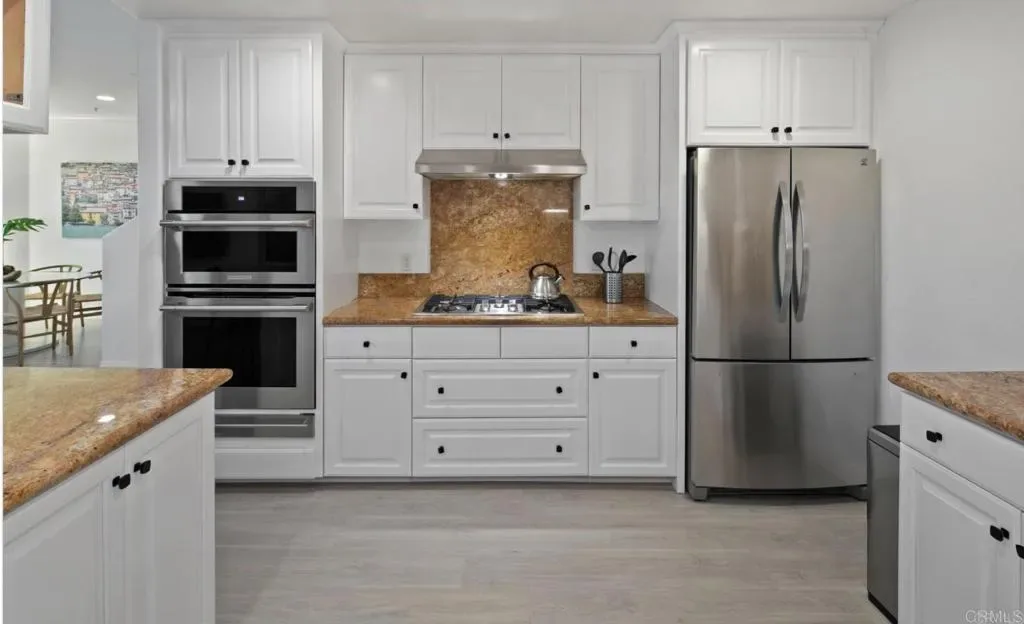 Double ovens, gas cooktop and full-size refrigerator in the kitchen