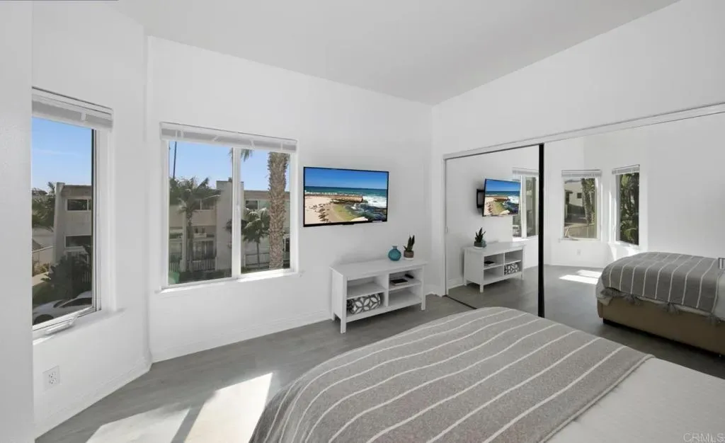 Bedroom with queen bed, television and closet