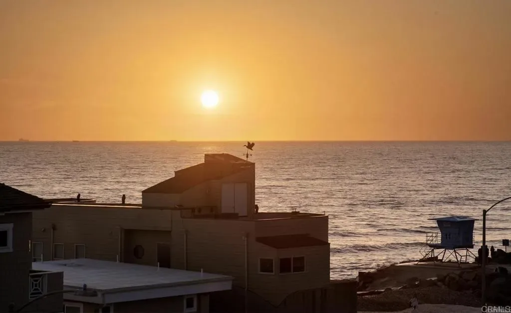 Sun dropping into the ocean beyond the rooftop deck