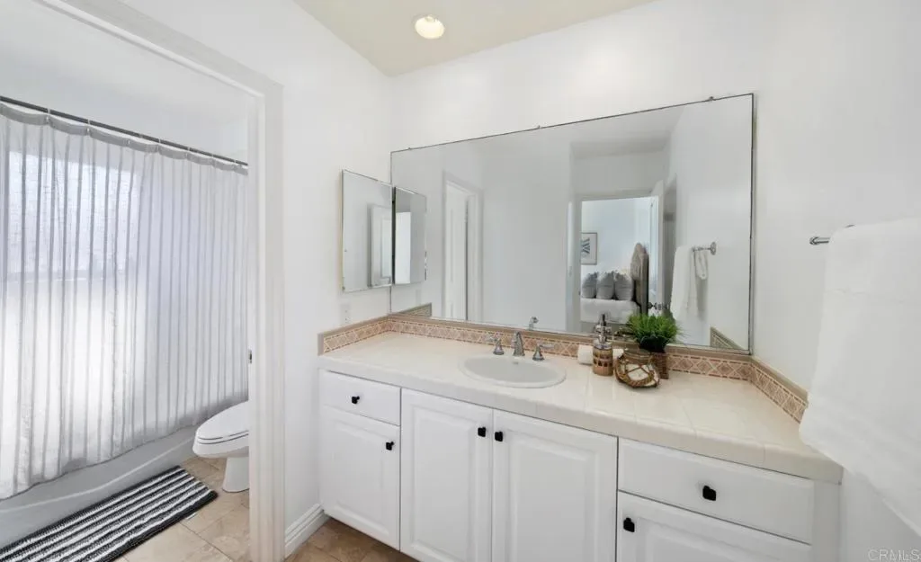 Bathroom with vanity, mirror and window shades