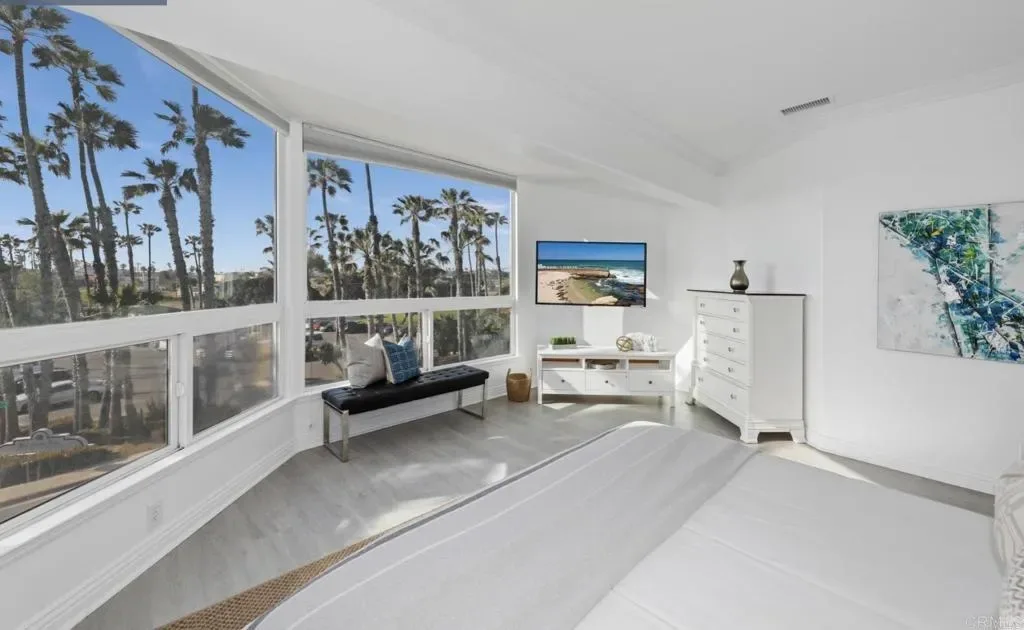 Bedroom with wraparound windows and palm views