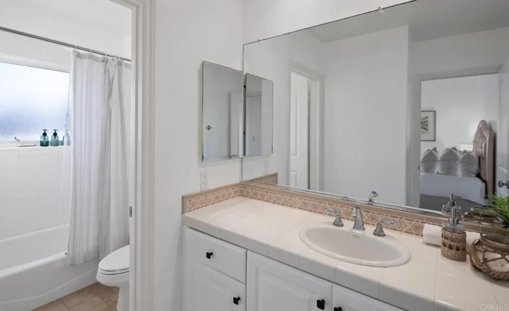 Bathroom with shower over tub and tiled counter