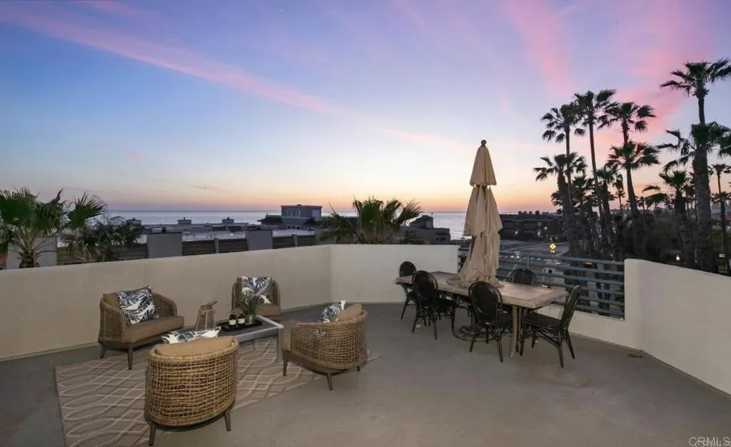 Rooftop deck in pink evening light above the rooftops