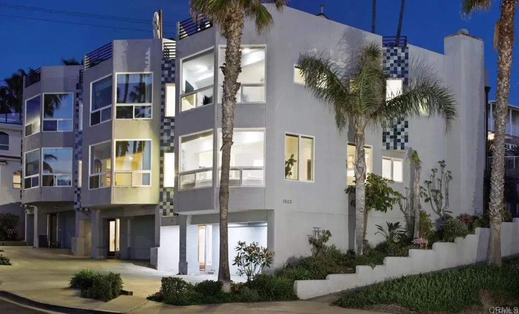 Front elevation of the three-level contemporary beach home at dusk
