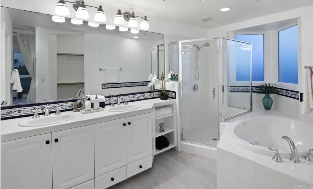 Primary bathroom with double vanity, jetted tub and glass shower