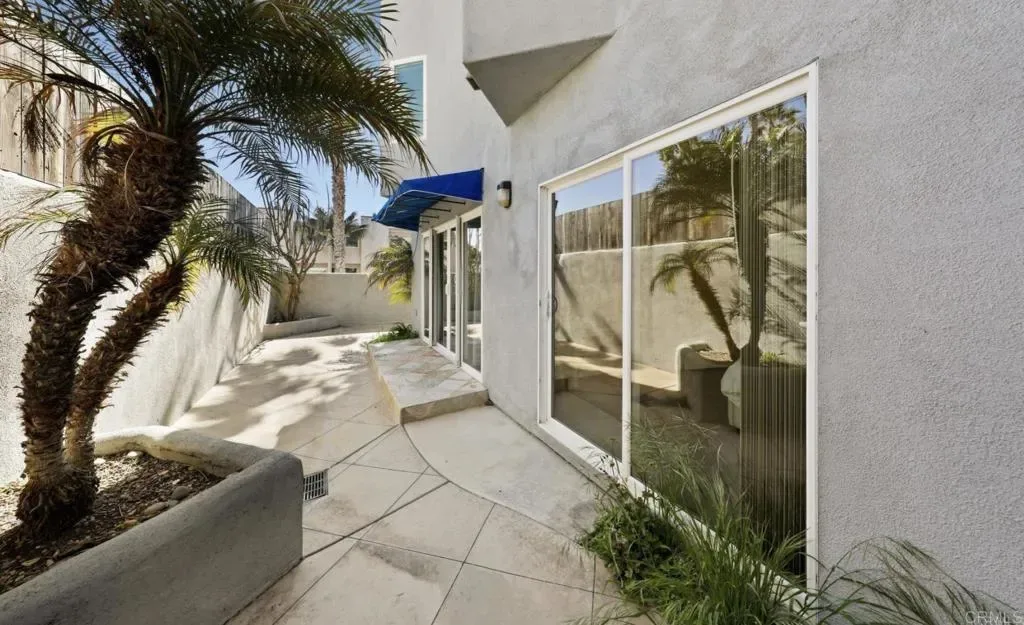 Private ground-level patio with palms and paved terrace