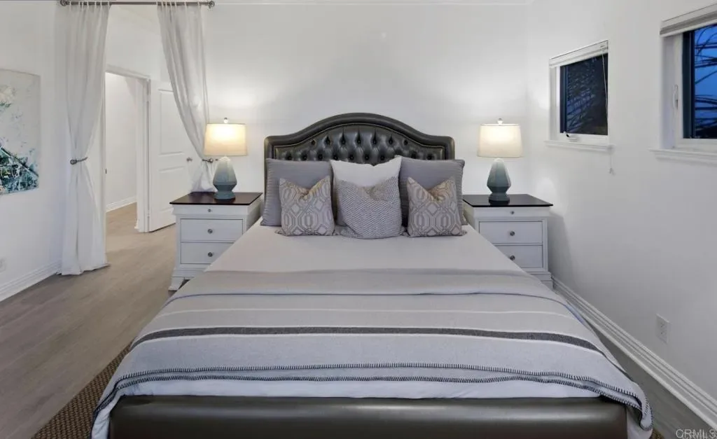 Bedroom with upholstered king bed and twin nightstands