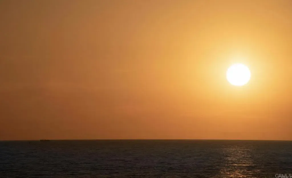 Sun sitting on the horizon over the ocean