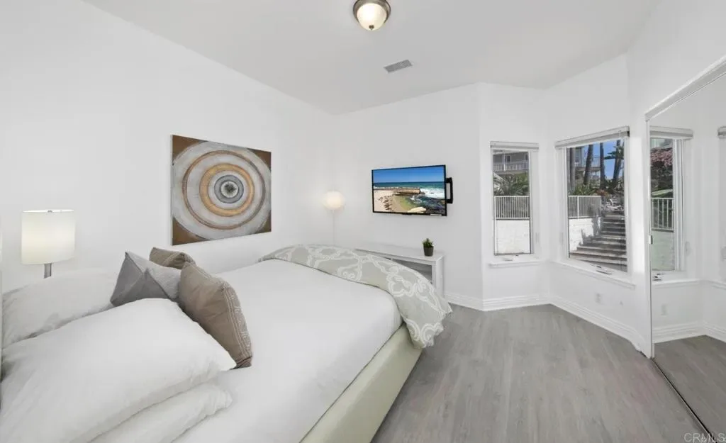 Guest bedroom with queen bed and bright corner windows