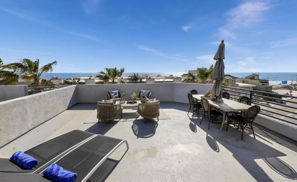 Rooftop deck lounge chairs and ocean panorama by day