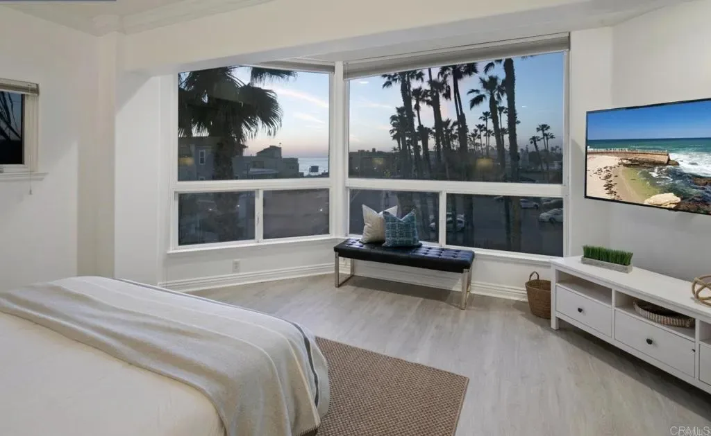 Primary bedroom with corner windows and king bed